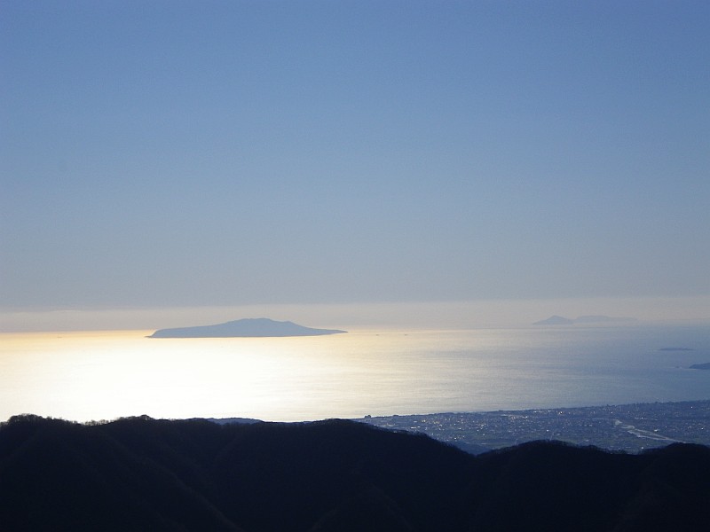 太陽を反射して輝く海面に浮かぶ伊豆大島。