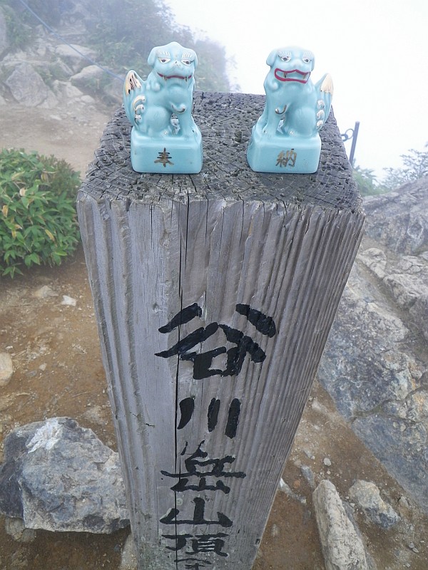 谷川岳の最高峰『オキノ耳（谷川富士）』。道標上に可愛らしい狛犬が。