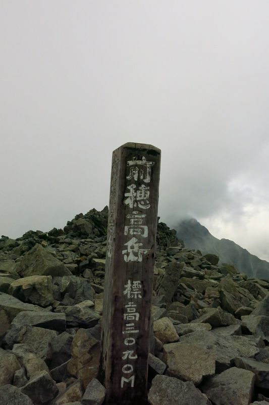 本来の眺望とは程遠いガス景色の前穂高岳山頂。